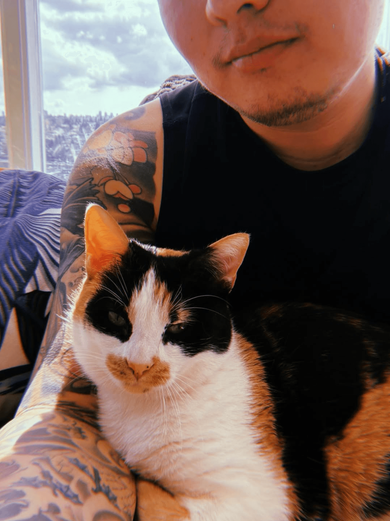 David Ly at home with his calico cat